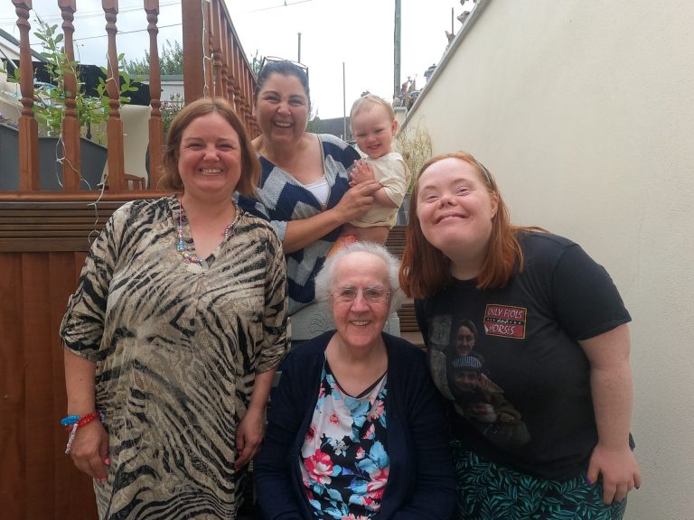 Shared Lives South West household, smiling in the garden. It includes three people supported, the carer and her grandson
