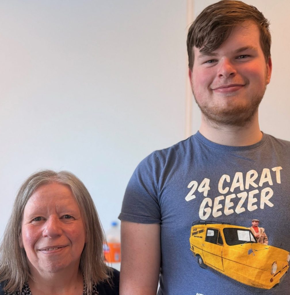 Pictured is Shared Lives Carer Ruth with Aaron who she supports. They are pictured inside and smiling.